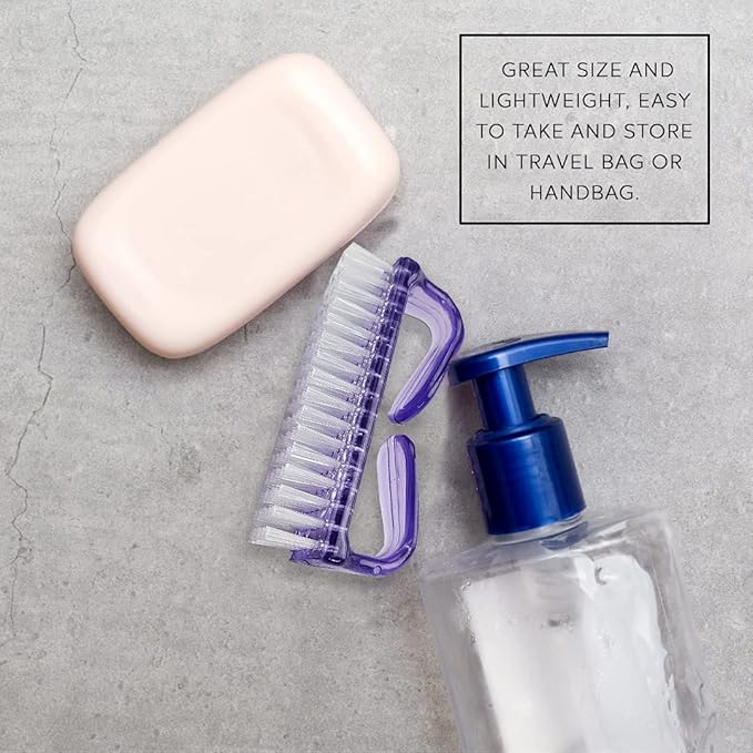 La Cross Nail Brush placed next to hand soap and lotion on a towel, ideal for personal hygiene routines